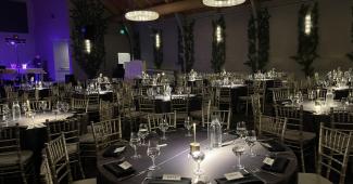 Elegant indoor corporate event setup at one of the premier event venues in California with banquet tables and ambient lighting.