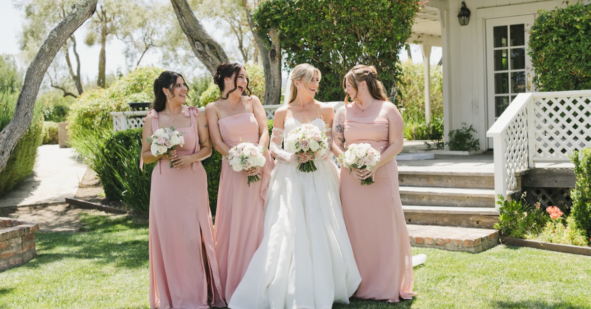 Bride and bridesmaids in blush dresses celebrating at a vineyard wedding venue in Hollister CA