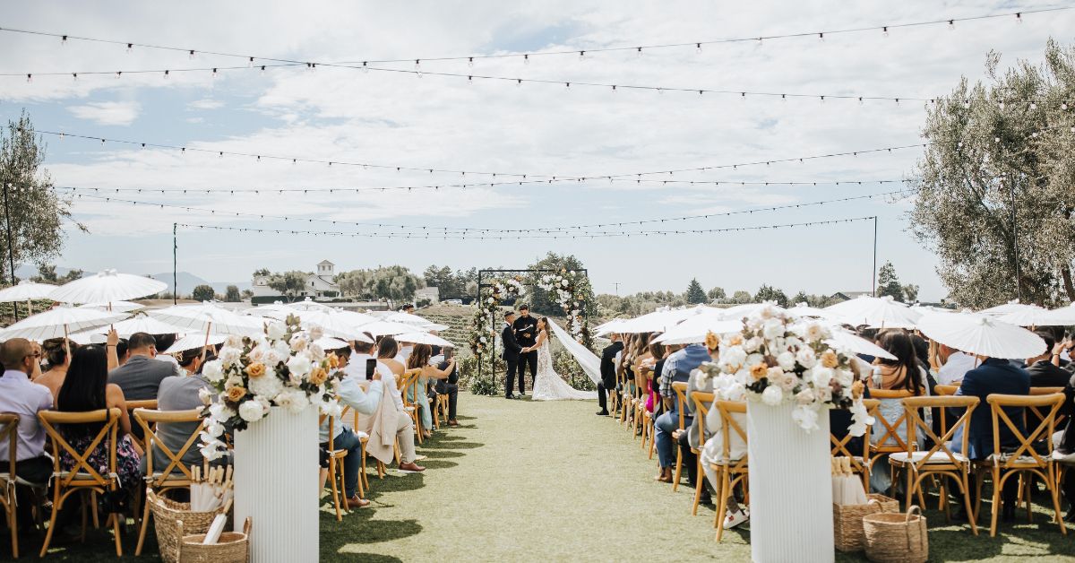 Outdoor vineyard ceremony with floral arch and string lights at Léal Vineyards, highlighting romantic wedding venues in Morgan Hill