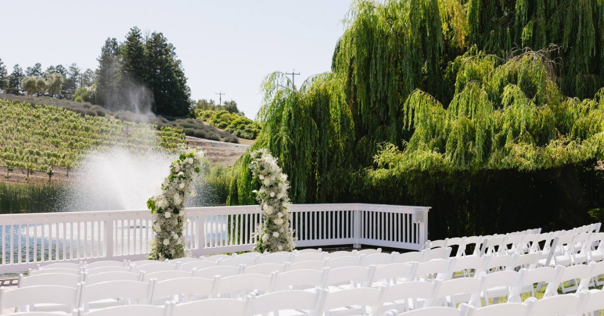 Outdoor wedding ceremony setup with white chairs