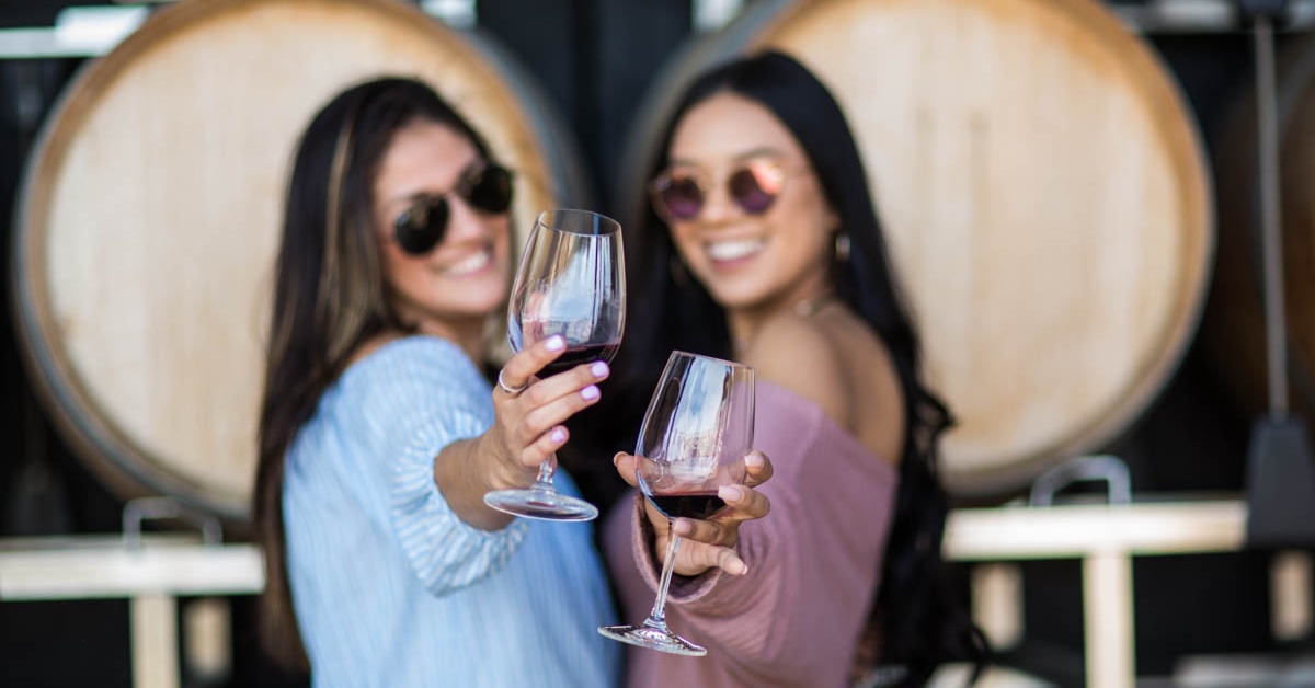 Guests toasting red wine inside a California vineyard wedding and winery venue