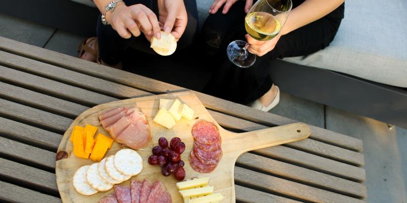 Charcuterie board and white wine enjoyed outdoors in California wine country near a vineyard wedding venue