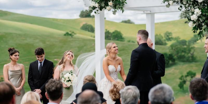 California vineyard wedding ceremony with scenic hills and outdoor arbor setting