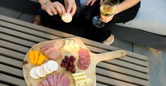 Charcuterie board and white wine enjoyed outdoors in California wine country near a vineyard wedding venue