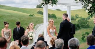 California vineyard wedding ceremony with scenic hills and outdoor arbor setting
